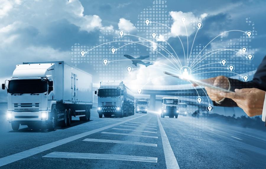 Trucks driving on the highway. Man overlayed on top, holding a tablet where directions are flowing out of.