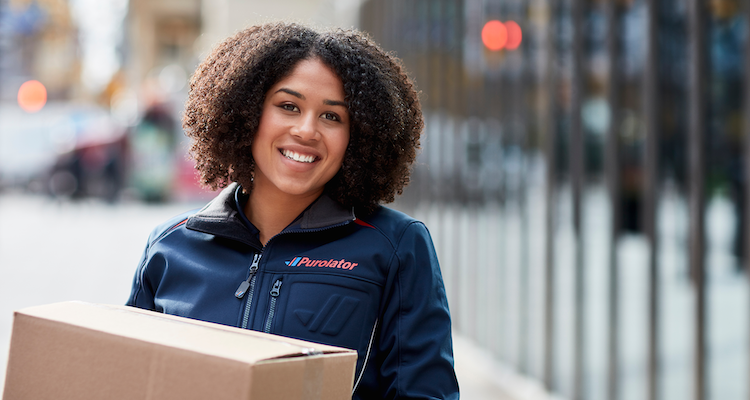 Female Purolator courier carrying a box