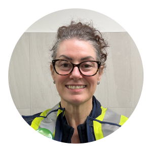 A woman wearing black-rimmed glasses and a yellow high‑visibility safety vest over a dark jacket stands against a simple indoor background. The graphic features the heading “International Women’s Day” and the quote: “We are all eligible to be considered for opportunity.” Purolator branding appears beneath the quote.